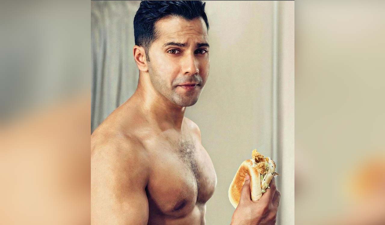 Varun Dhawan chomps on burgers, flaunts his abs on ‘cheat day’